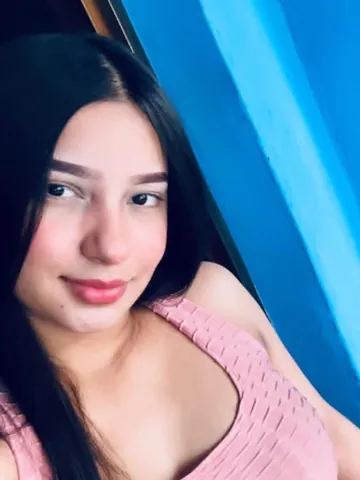 Lady with long dark hair in front of a blue wall
